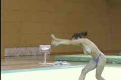 Topless gymnast performs amazing tricks