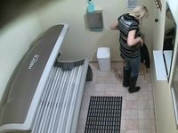 A young blonde gets naked and lays on the tanning bed